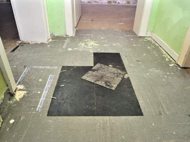 Schwarzer Kleber unter PVC Platten – Foto 3