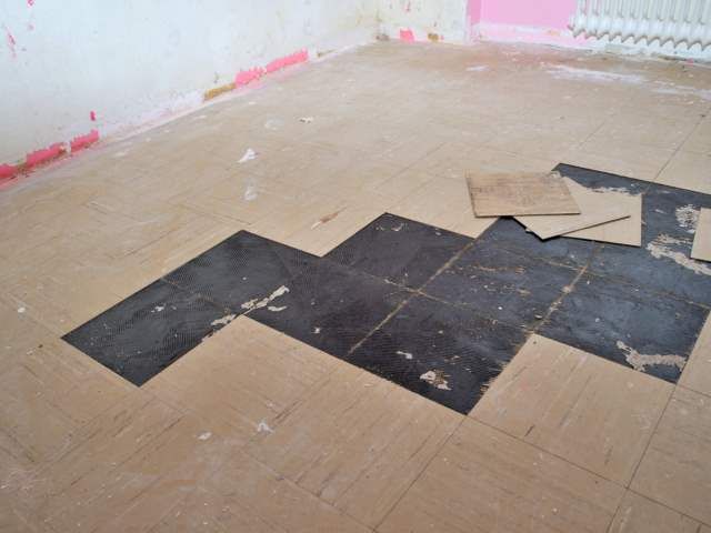 Schwarzer Kleber unter PVC Platten – Foto 1