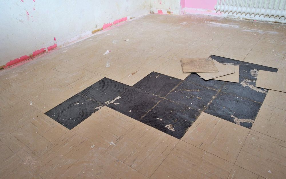 Schwarzer Kleber unter PVC Platten – Foto 2